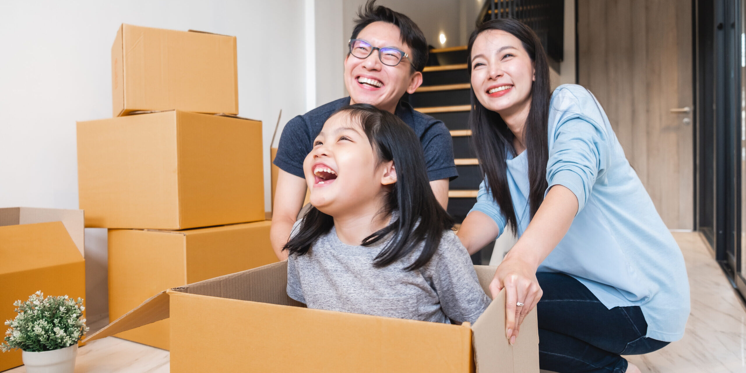 Asian family moving to new home / apartment with many packing boxes