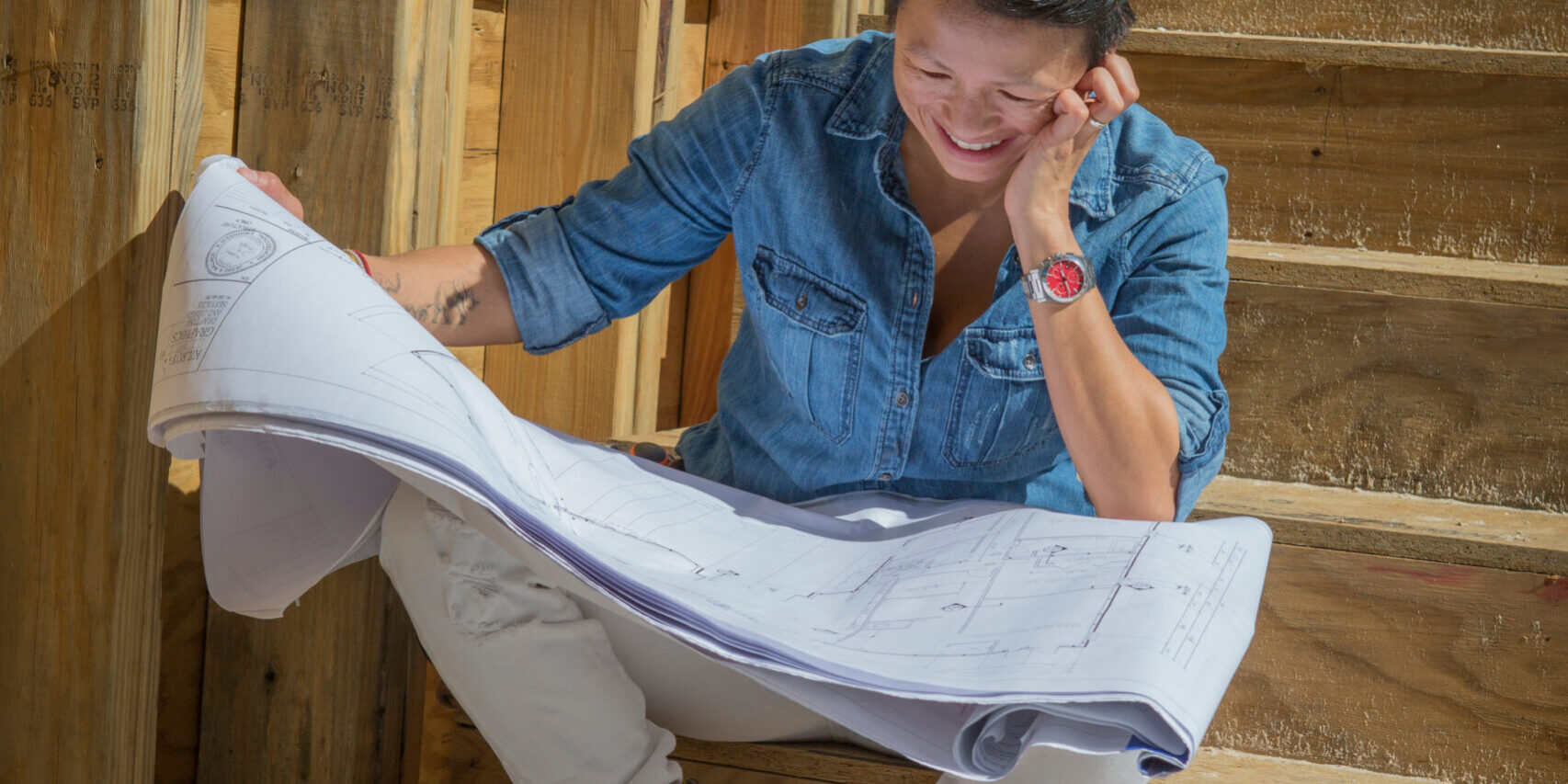 Mid adult woman studying blueprints to her own home