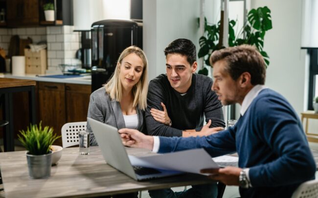 California couple meeting with a licensed mortgage broker to review pre-approval documents on a laptop
