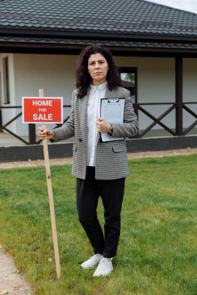Texas real estate investor at an investment property with home sign
