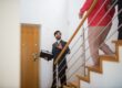 Virginia real estate agent leading buyers through staircase in modern home