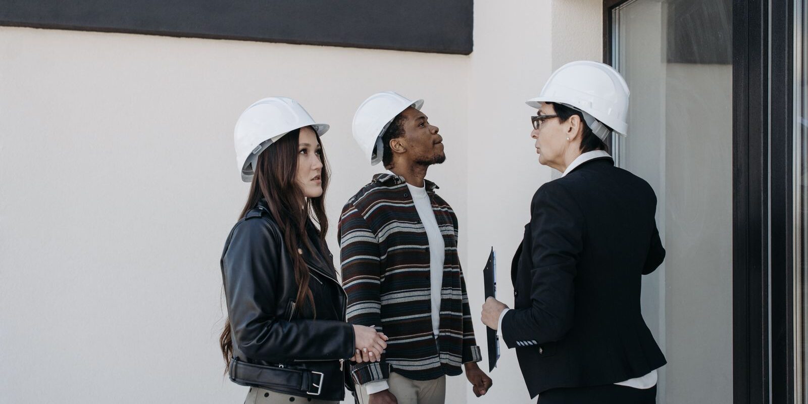 Real estate investors reviewing property plans on-site, evaluating a potential DSCR loan-financed rental property acquisition