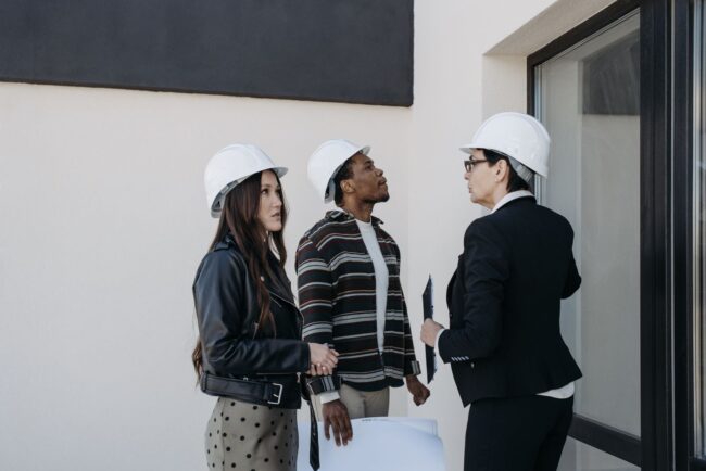 Real estate investors reviewing property plans on-site, evaluating a potential DSCR loan-financed rental property acquisition