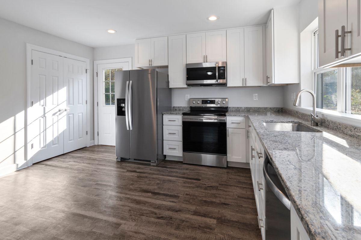 Bright, newly renovated modern kitchen with white cabinets and granite counters funded by a home equity line of credit