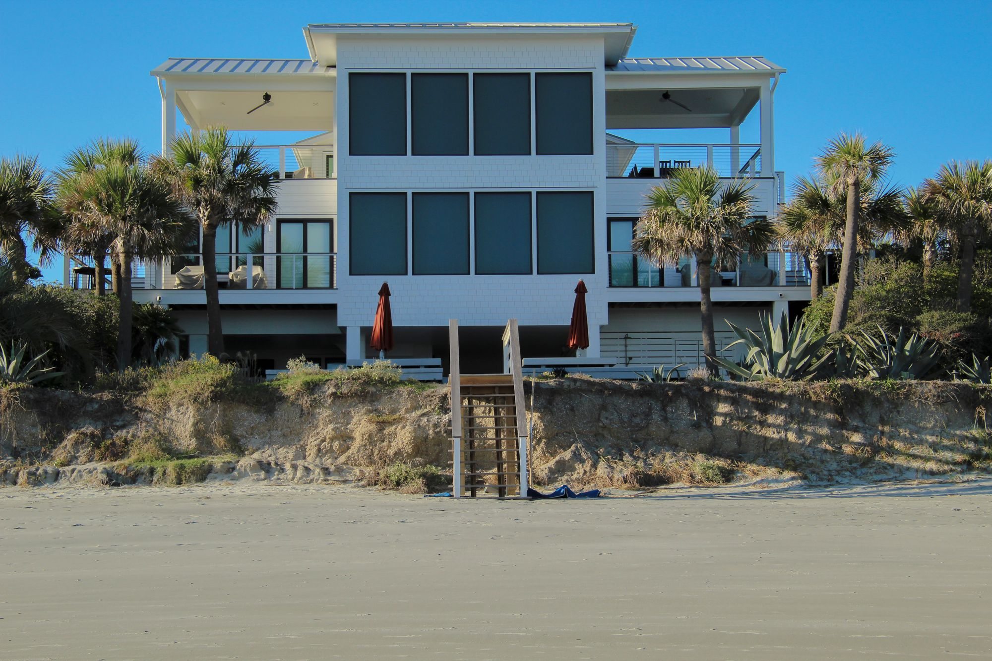 Modern beachfront vacation rental home with palm trees