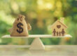 Money bag on one side of a balance scale weighed against a wooden house with family silhouette on the other, representing the home equity loan vs cash-out refinance decision