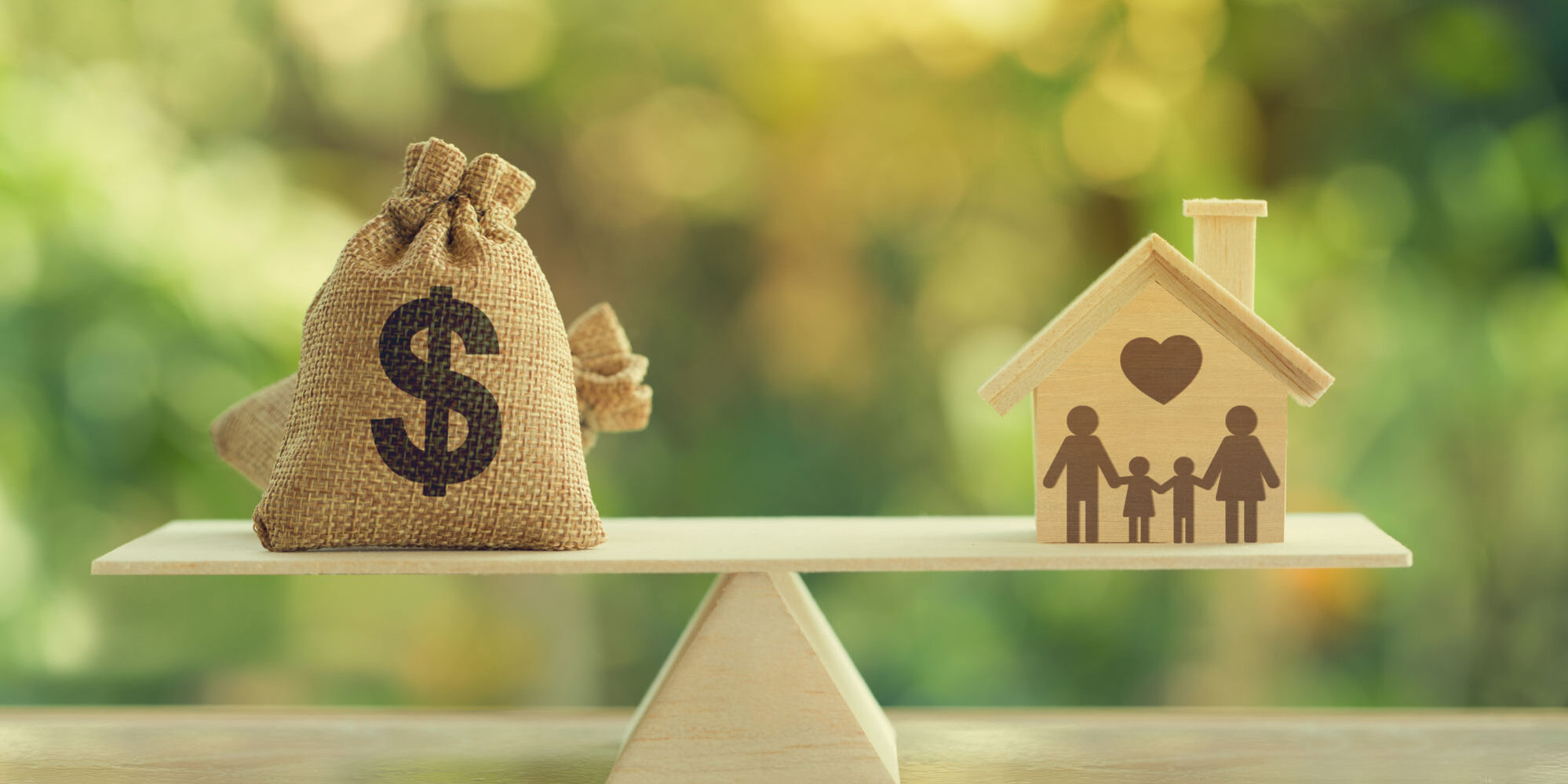 Money bag on one side of a balance scale weighed against a wooden house with family silhouette on the other, representing the home equity loan vs cash-out refinance decision
