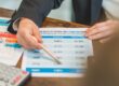 Hands reviewing mortgage rate documents with calculator, representing the buyer decision moment after 30-year mortgage rates rose to 6.66 percent in the wake of hawkish Fed dissent