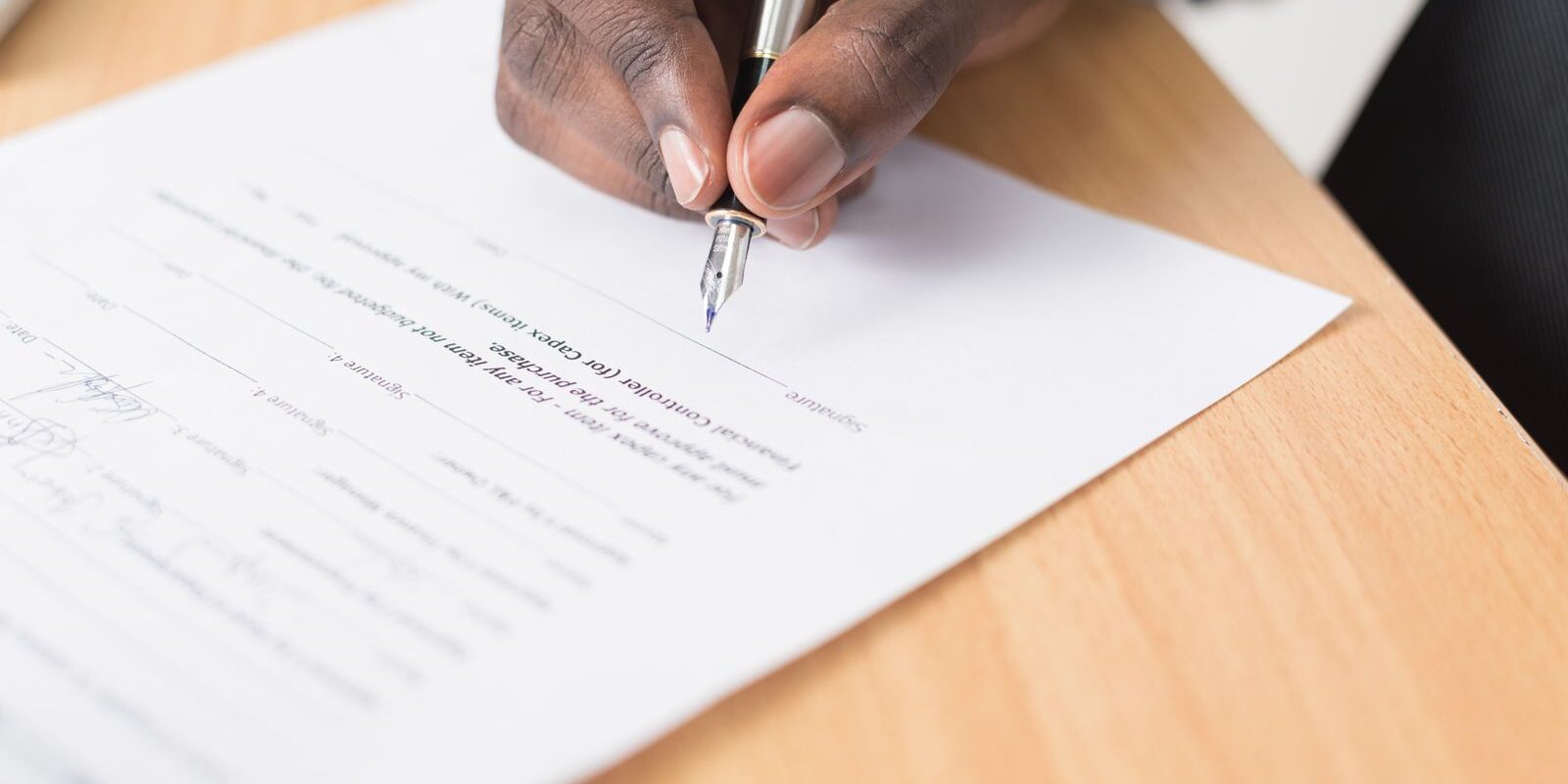 rate-lock-strategy-september-fomc-2026 Pen poised over mortgage document, representing the rate lock decision facing buyers and refinancers ahead of the September 15-16 FOMC meeting