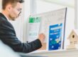 Mortgage broker analyzing refinance loan details on a whiteboard, representing the decision framework for homeowners considering refinance timing in August 2026