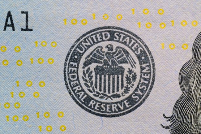 US Federal Reserve seal on currency with digital numbers overlay — hawkish dissent hike risk visualization