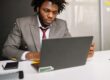 Focused professional analyzing the August 2026 jobs report at his laptop to determine the impact on mortgage rates and the upcoming September Federal Reserve decision