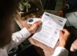 Homeowner reviewing financial paperwork at a wooden desk under natural light, weighing the tradeoffs between a HELOC, a home equity loan, and a cash-out refinance in the higher-for-longer mortgage rate environment of September 2026