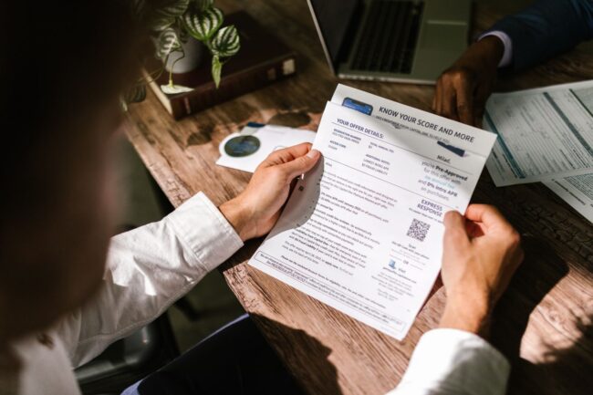 Homeowner reviewing financial paperwork at a wooden desk under natural light, weighing the tradeoffs between a HELOC, a home equity loan, and a cash-out refinance in the higher-for-longer mortgage rate environment of September 2026