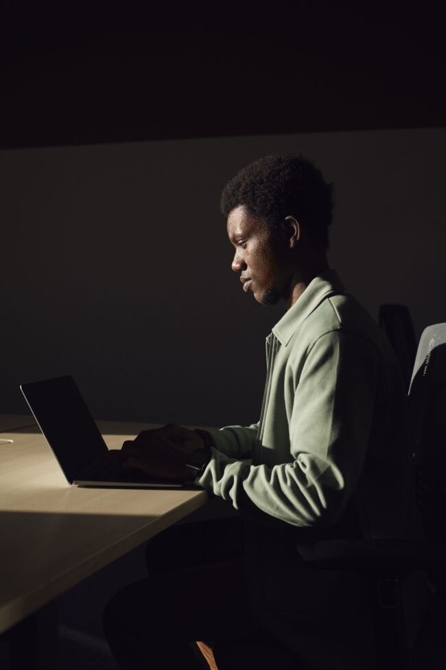 Professional deeply focused on his laptop in profile view, running the lock vs float mortgage rate decision math 48 hours before the September 16 FOMC decision under Federal Reserve Chair Kevin Warsh