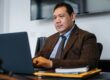 Focused Latino professional working at his desk on his laptop reviewing a No Points Refinance quote comparison for his mortgage in 2026