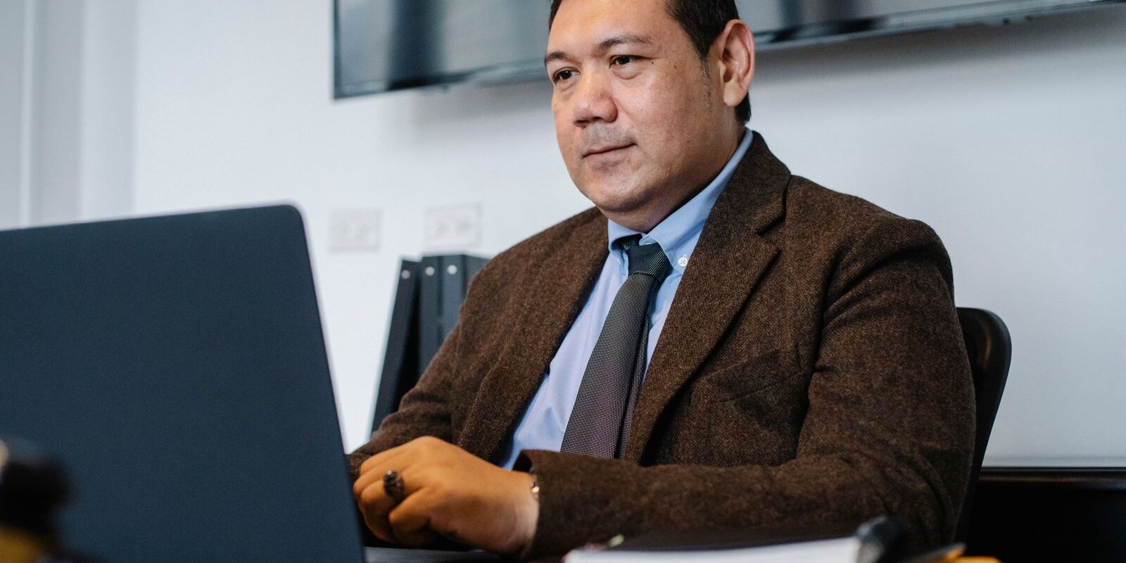 no-points-refinance-zero-points-program-2026 Focused Latino professional working at his desk on his laptop reviewing a No Points Refinance quote comparison for his mortgage in 2026