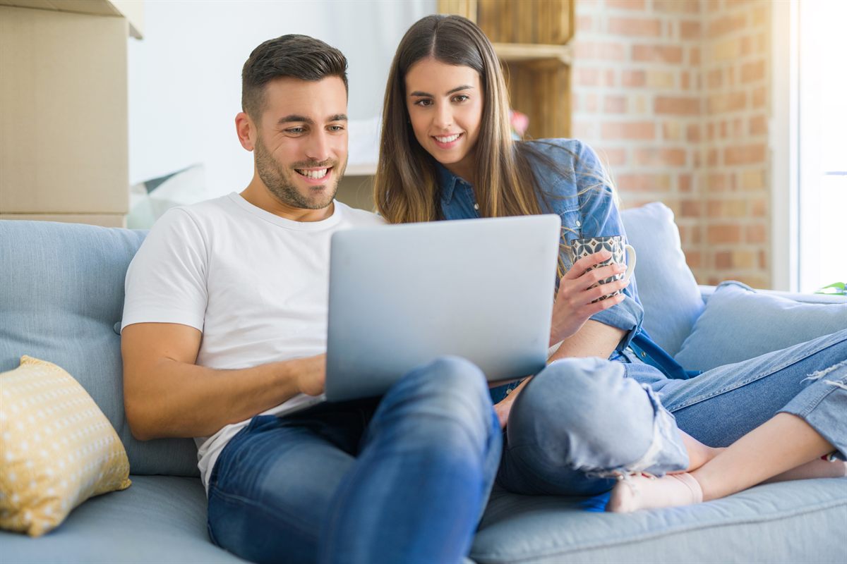 Young couple pricing their own mortgage online on a laptop at home