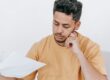 Latino professional at his home office desk carefully examining a Loan Estimate financial report on his laptop, running the 8-point September 2026 rate shopping checklist across lender quotes before the September 16 Federal Reserve decision