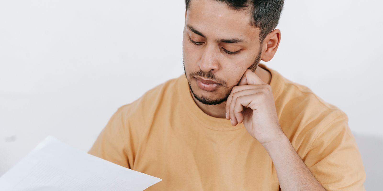 rate-shopping-checklist-2026 Latino professional at his home office desk carefully examining a Loan Estimate financial report on his laptop, running the 8-point September 2026 rate shopping checklist across lender quotes before the September 16 Federal Reserve decision
