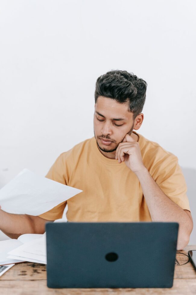 Latino professional at his home office desk carefully examining a Loan Estimate financial report on his laptop, running the 8-point September 2026 rate shopping checklist across lender quotes before the September 16 Federal Reserve decision