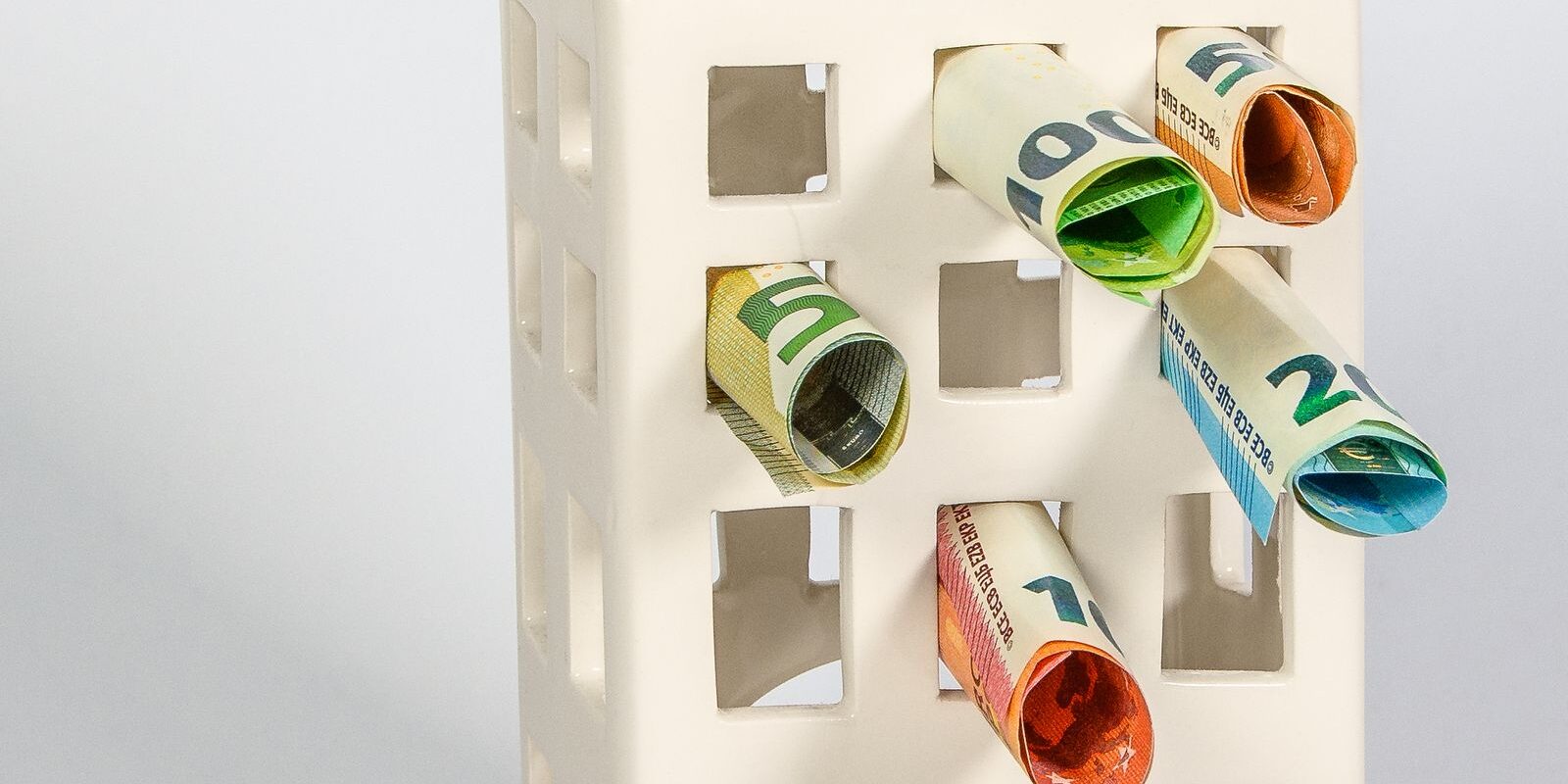 day02-down-payment-piggy-bank-2026 A house-shaped piggy bank filled with cash and coins, representing the down payment savings needed to buy a home in October 2026 and the full range of 0%, 3%, 3.5%, 5%, 10%, and 20% down payment loan program options