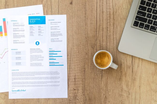 Mortgage Employment History 2 Year Rule 2026 Resume, coffee, and laptop on a desk representing employment history review for mortgage qualification