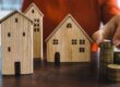 Model houses with stacks of coins representing savings for a home purchase: down payment, closing costs, and reserves