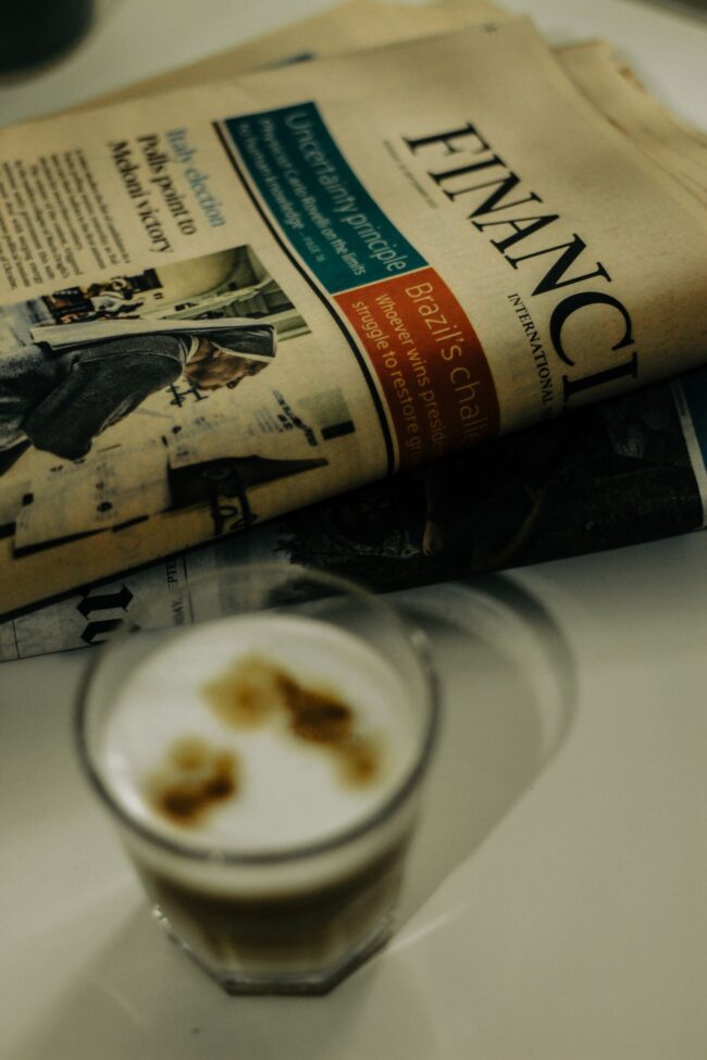 Financial newspaper with coffee cup on desk, representing the news reaction to the September 2026 BLS Employment Situation Report cold print and downward revisions and what the dovish labor market surprise means for mortgage rates